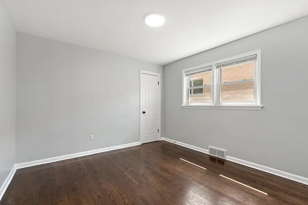 an empty room with closet and windows