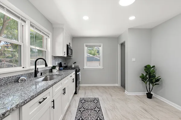 a kitchen with stainless steel appliances granite countertop a stove a sink and a microwave