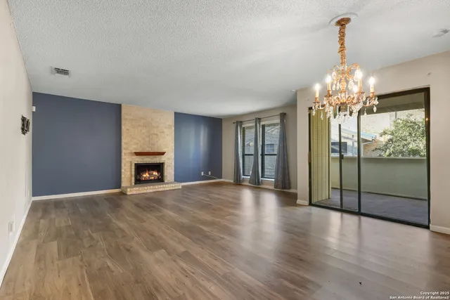 a view of an empty room with glass door and windows