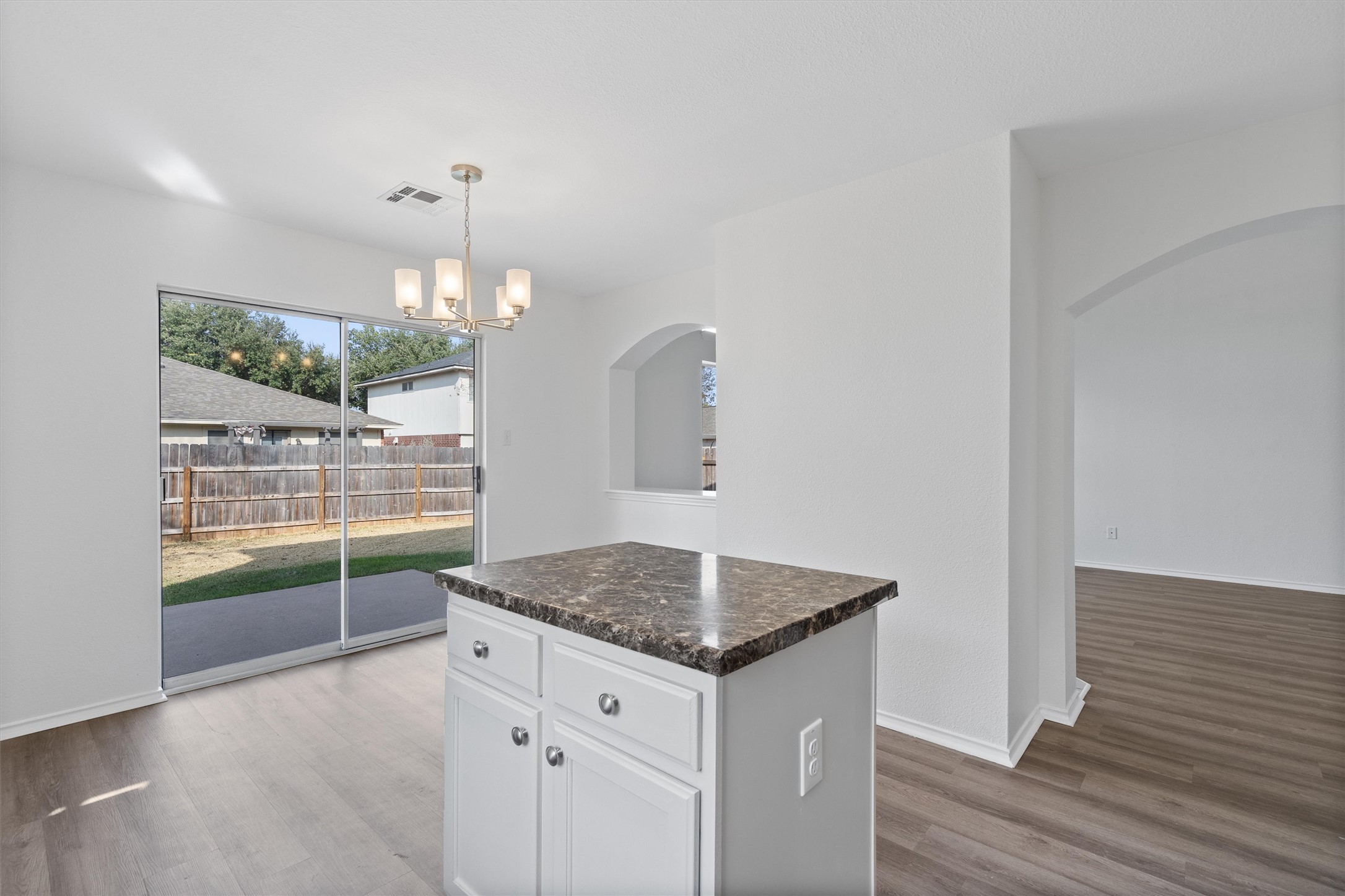 2101 Jester Farms Road Round Rock, TX 78664 - Photo 8 of 24 Kitchen featuring white cabinetry, arched walkways, decorative light fixtures, and dark wood finished floors