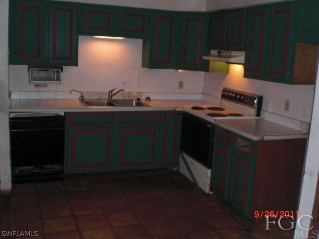 7429 Albany Road Fort Myers, FL 33967 - Photo 3 of 20 a kitchen with a sink stove and cabinets