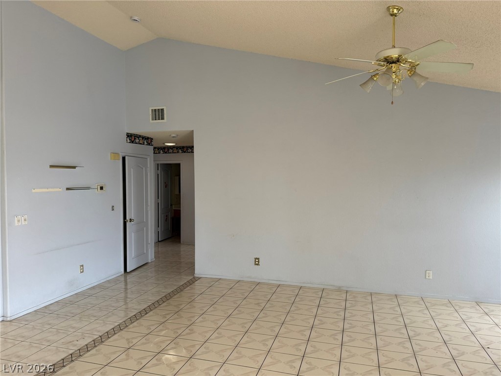 277 Gentle Bay Avenue Henderson, NV 89074 - Photo 23 of 43 This living space features vaulted ceilings and classic tiled flooring, creating an expansive feel.