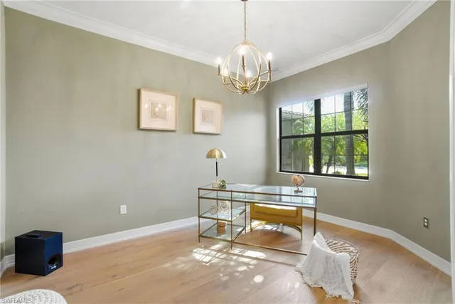 a dining room with wooden floor a chandelier a wooden table and chairs