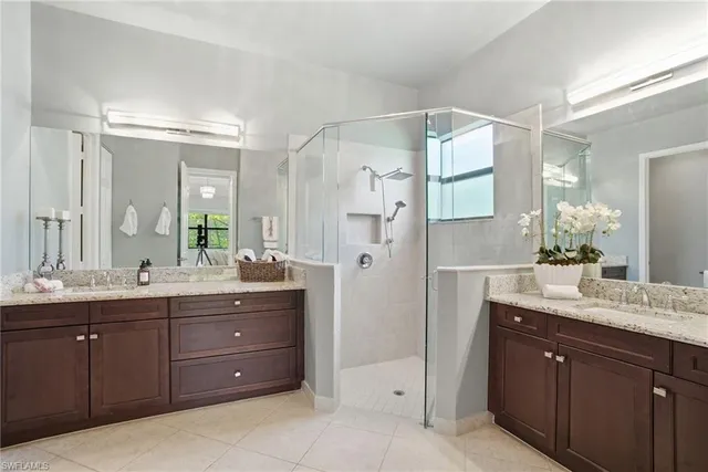 a bathroom with a granite countertop sink mirror and a shower