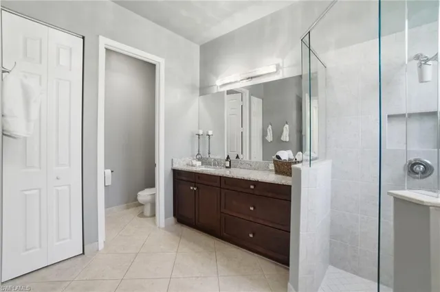 a spacious bathroom with a double vanity sink toilet and shower