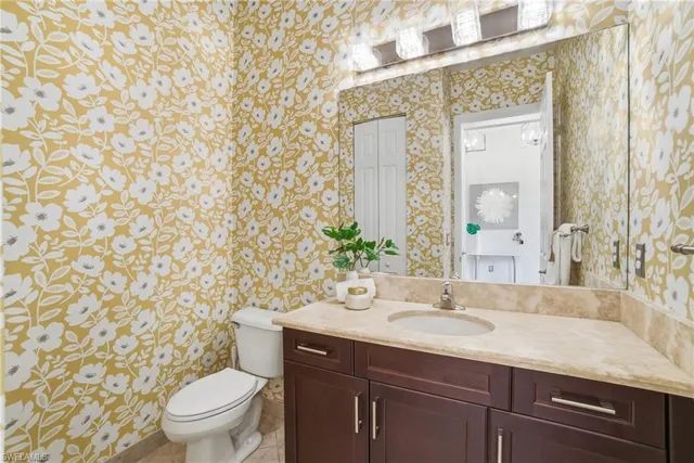 a bathroom with a granite countertop sink a toilet and a mirror