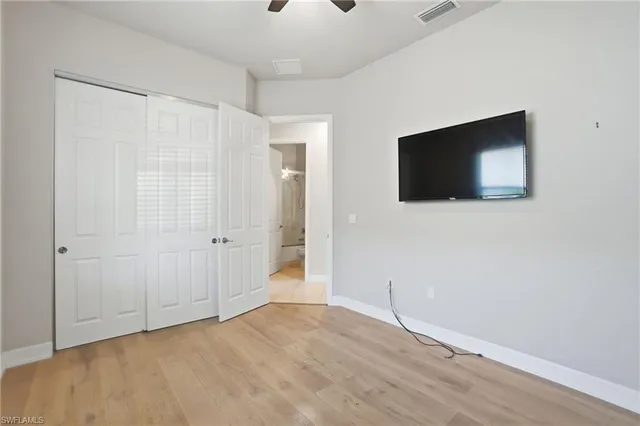 a view of a livingroom with wooden floor and a flat screen tv