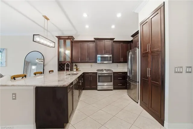 a kitchen with stainless steel appliances granite countertop a refrigerator a stove a sink and a oven