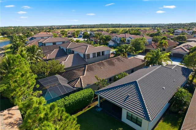an aerial view of residential houses with outdoor space and ocean view