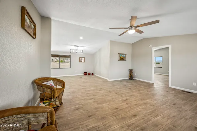 a kitchen with stainless steel appliances a refrigerator a stove a sink dishwasher and white cabinets with wooden floor