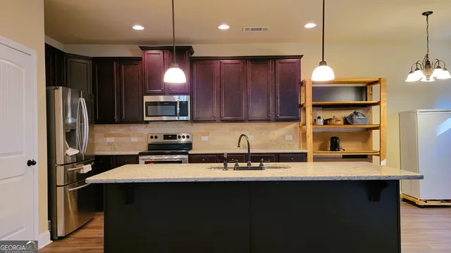 a kitchen with stainless steel appliances granite countertop sink a stove and refrigerator