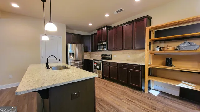a kitchen with granite countertop wooden cabinets and stainless steel appliances