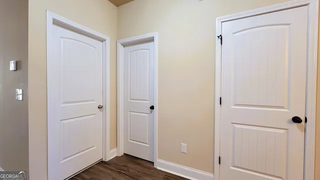 a view of staircase with wooden floor and white walls