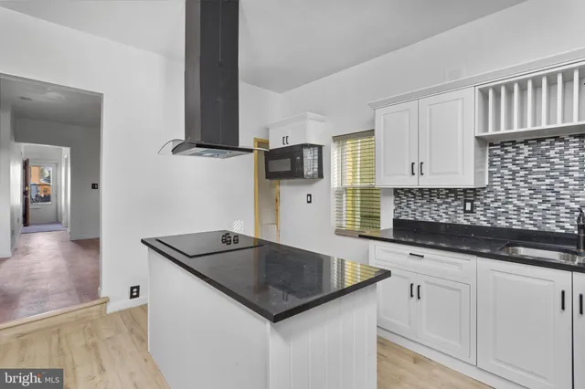 a kitchen with granite countertop a sink and a stove