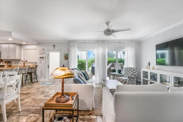 a living room with furniture a flat screen tv and kitchen view