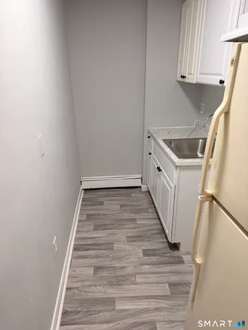 a view of a kitchen with white cabinets and wooden floor