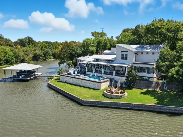 an aerial view of a house with swimming pool garden and lake view