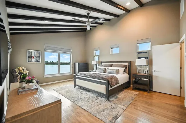 a spacious bedroom with a bed and wooden floor