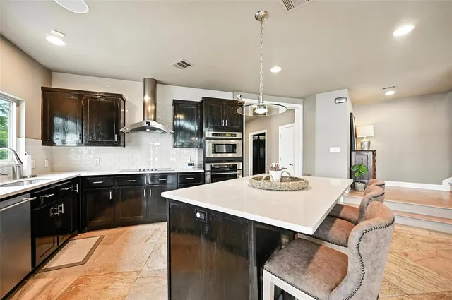 a large kitchen with kitchen island a large island in it