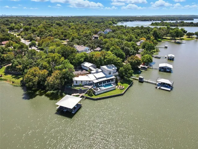 an aerial view of a house with a yard and lake view