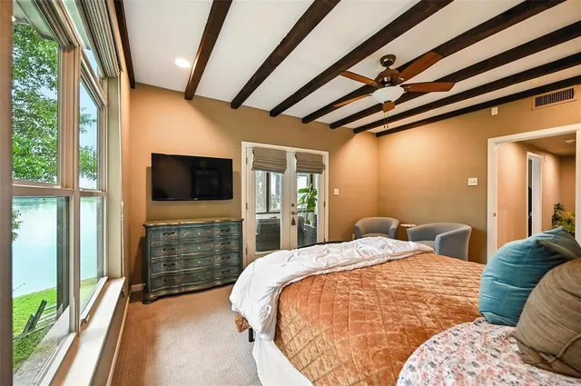 a spacious bedroom with a bed and a flat screen tv