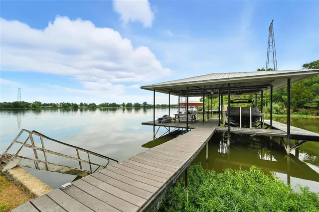 a view of a lake with couches chairs and wooden floor