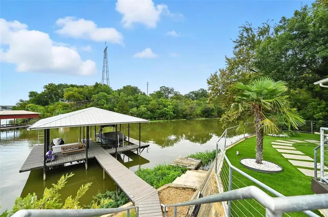 a view of a swimming pool with a table and chairs under an umbrella