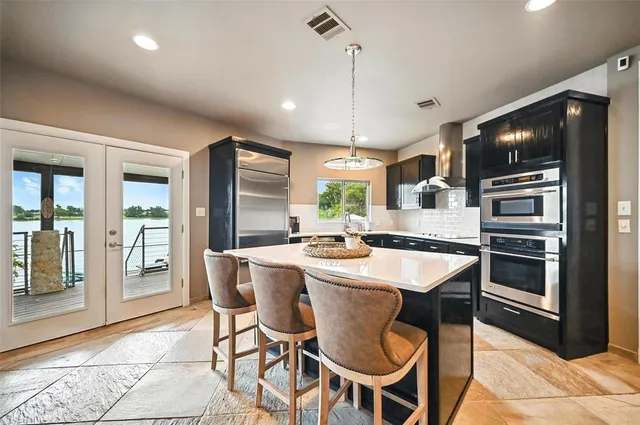 a kitchen with a dining table chairs and refrigerator