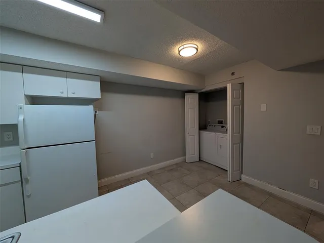 a view of an empty room with a chandelier fan