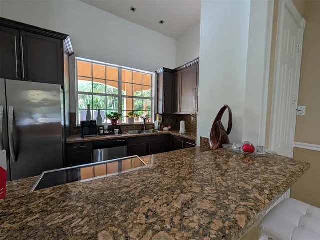 a kitchen with granite countertop a refrigerator and a sink