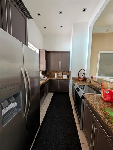a kitchen with stainless steel appliances granite countertop a sink a stove and a refrigerator