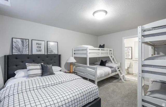 4846 Fishers Is Way St. George, UT 84770 - Photo 7 of 13 Spacious bedroom featuring neutral wall tones, plush carpet flooring, a flush-mount ceiling light, and access to a full bathroom with a vanity and toilet