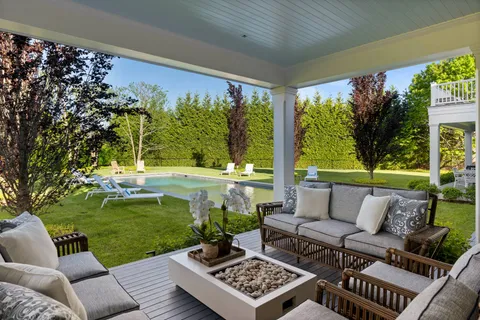 a living room with patio furniture and a garden