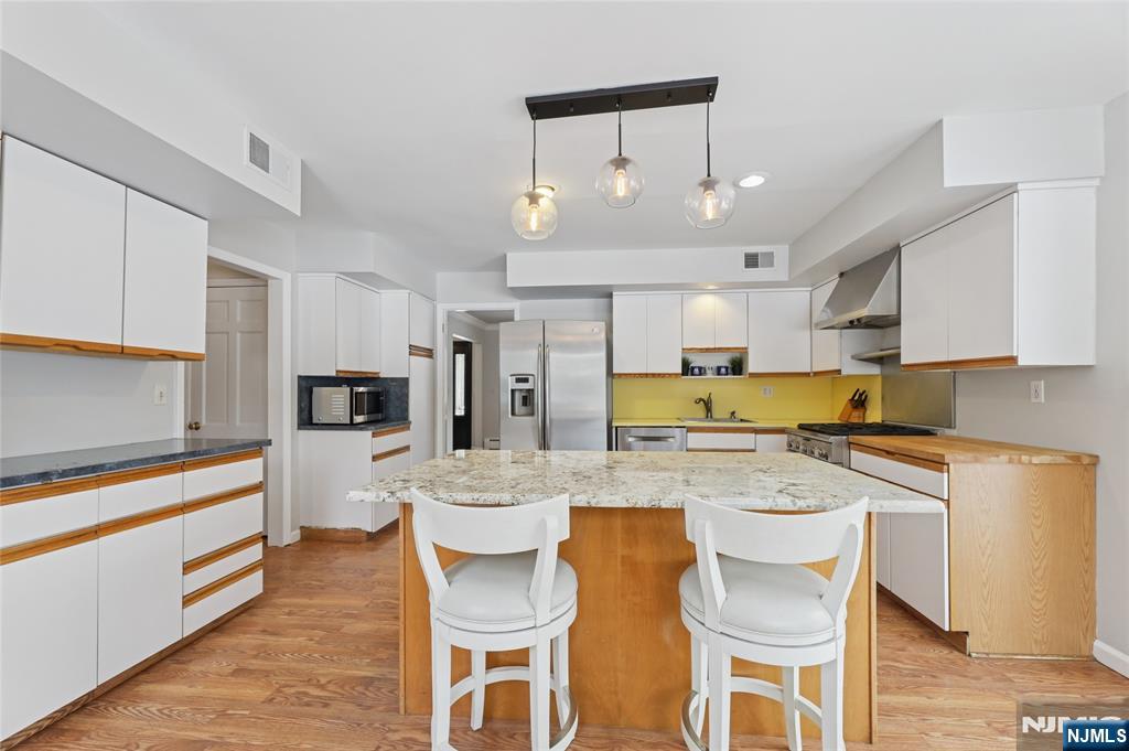 320 Park Street Haworth, NJ 07641 - Photo 20 of 48 a kitchen with a dining table chairs refrigerator and microwave