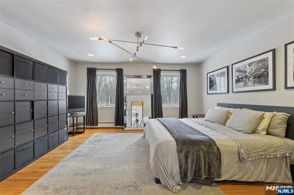 320 Park Street Haworth, NJ 07641 - Photo 28 of 48 a spacious bedroom with a large bed and a chandelier