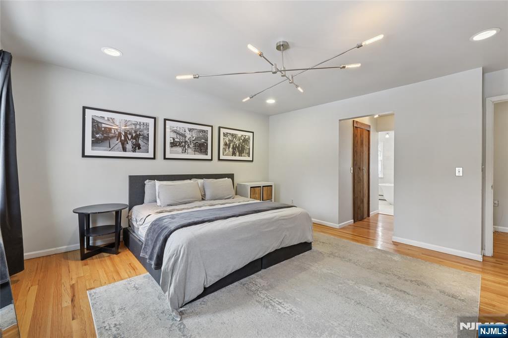 320 Park Street Haworth, NJ 07641 - Photo 30 of 48 a spacious bedroom with a large bed and a chandelier