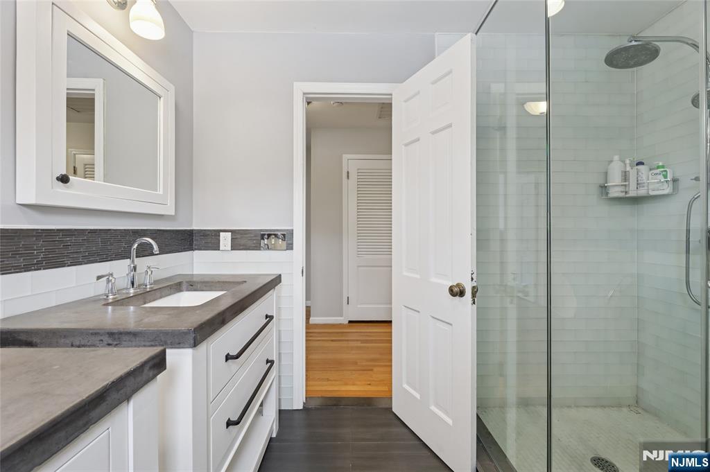 320 Park Street Haworth, NJ 07641 - Photo 40 of 48 a bathroom with a granite countertop sink and a mirror