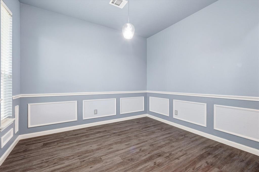 4545 Ridgepointe Drive The Colony, TX 75056 - Photo 4 of 37 Spacious interior room featuring wood-finish flooring, wainscoting with decorative trim, a window with blinds, and a contemporary pendant light fixture