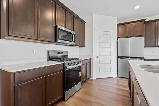 a kitchen with stainless steel appliances granite countertop a stove a sink and a refrigerator