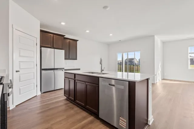 a kitchen with stainless steel appliances granite countertop a refrigerator and a sink