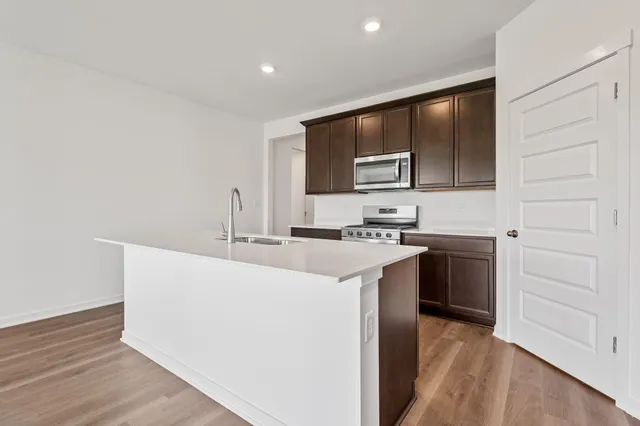 a kitchen with stainless steel appliances a sink stove and cabinets