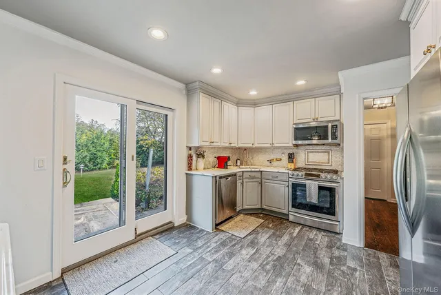 a kitchen with a refrigerator sink and large window