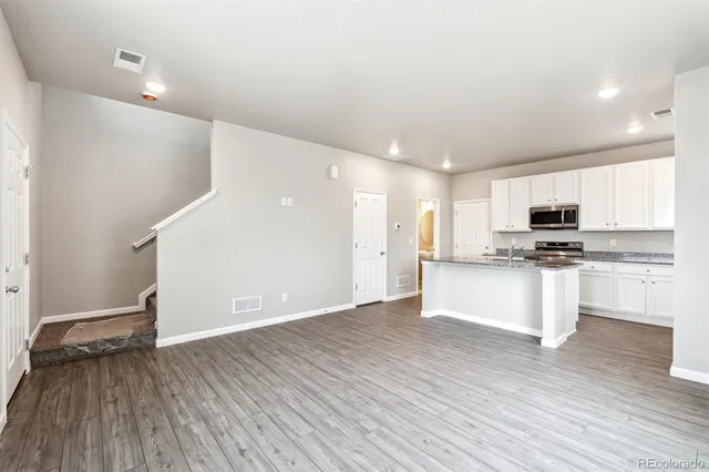 a view of kitchen with granite countertop cabinets and refrigerator