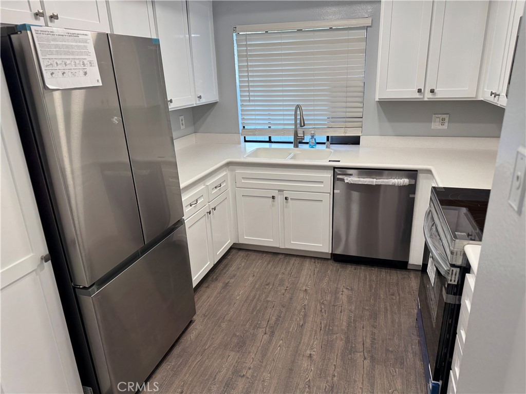 13602 La Jolla Circle, Unit B La Mirada, CA 90638 - Photo 12 of 27 a kitchen with stainless steel appliances a refrigerator sink and wooden floor