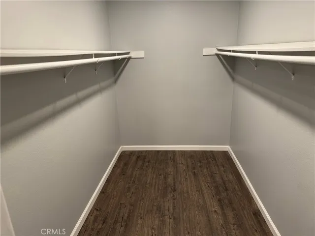 a view of walk in closet with wooden floor