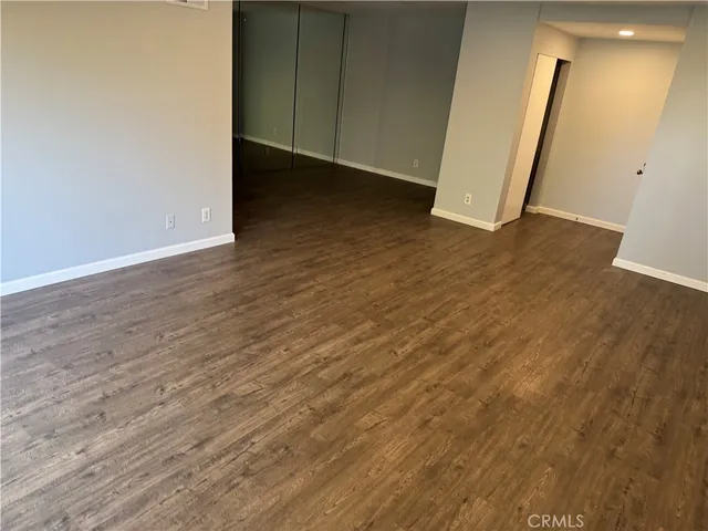 an empty room with wooden floor and entrance