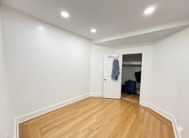 a view of empty room with wooden floor and sink