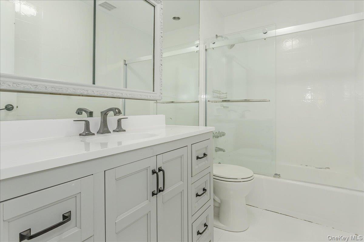 93 Searingtown Road Albertson, NY 11507 - Photo 13 of 24 Bathroom with vanity, enclosed tub / shower combo, and tile patterned floors
