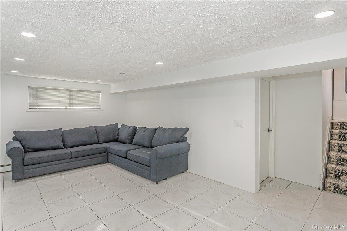 93 Searingtown Road Albertson, NY 11507 - Photo 14 of 24 Living area with a textured ceiling, recessed lighting, and light tile patterned floors