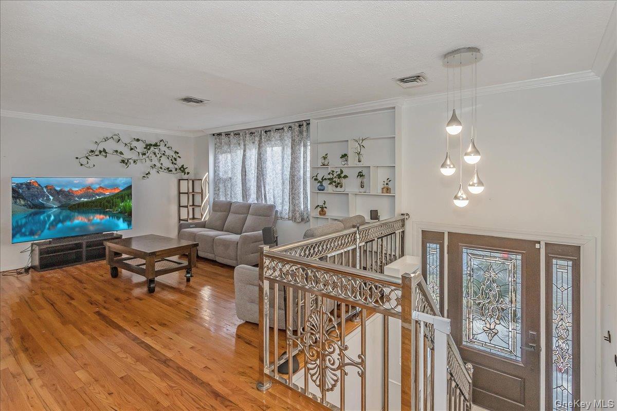93 Searingtown Road Albertson, NY 11507 - Photo 2 of 24 Living area with light wood-style floors and ornamental molding
